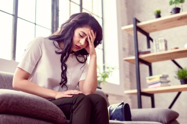 Alnının tutan ponponsuz yorgun genç kadın