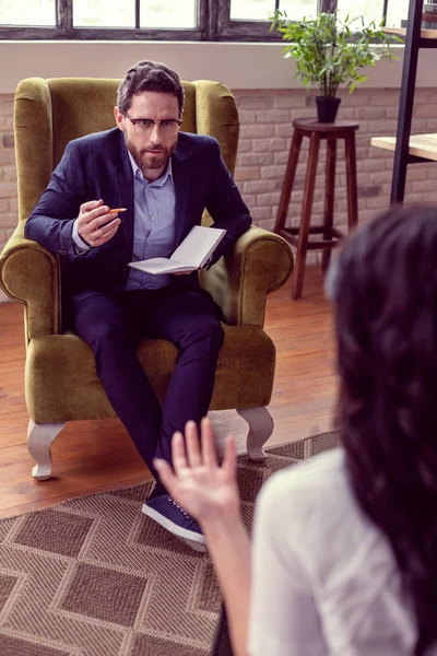 Хороший профессиональный психолог разговаривает со своим пациентом — стоковое фото