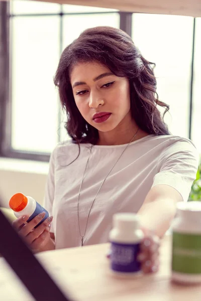 Niza mujer seria tomando un frasco con medicamentos — Foto de Stock