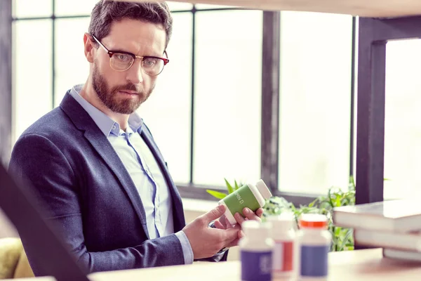 Intelligente bebaarde man met een fles met geneeskunde — Stockfoto