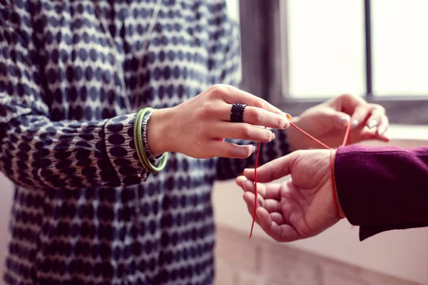 Enfoque selectivo de una pulsera roja en la mano masculina — Foto de Stock