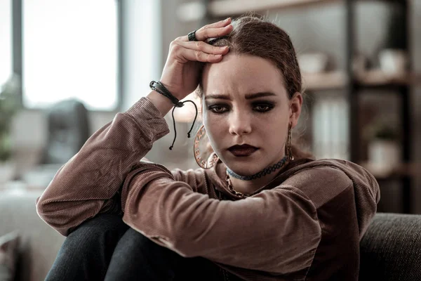 Koyu renk gözleri ve mutsuz hissediyor dudaklar esmer genç kızla