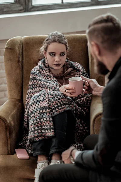 Девочка-подросток с дымчатыми глазами пьет чай у консультанта — стоковое фото