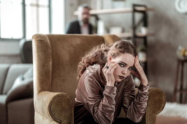 Koyu makyaj sahip kıvırcık saçlı esmer genç