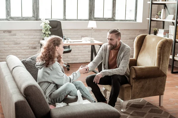 Bearded private counselor offering glass of water to his client — Stock Photo, Image