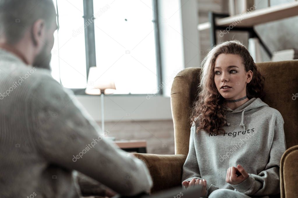 Teenage girl feeling involved in conversation with psychologist