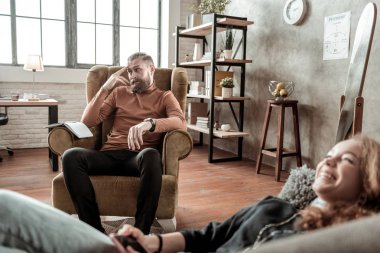 Neşeli genç psikolojik tedavi yaparken gülüyor