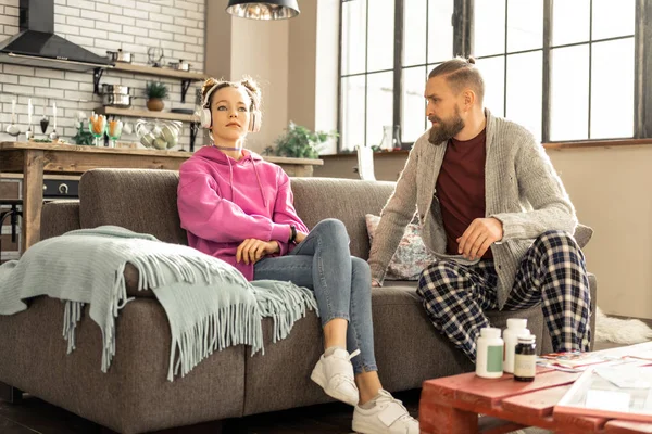 Daughter listening to music in earphones instead of talking — Stock Photo, Image