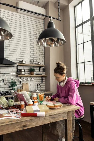 Tonåring sitter och gör läxor under frukosten — Stockfoto