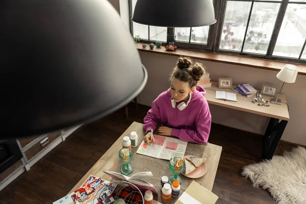 Εφηβικό κορίτσι που κάθεται στην κουζίνα και το γράψιμο σύνθεση — Φωτογραφία Αρχείου