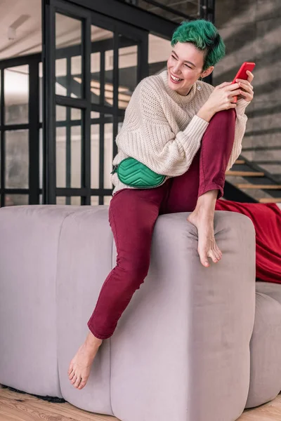 Frau chillt auf Sofa und scrollt in sozialen Medien — Stockfoto