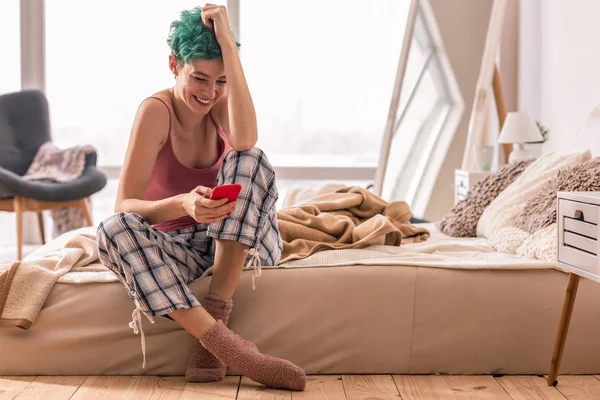 Woman wearing pajamas and warm socks feeling pleased