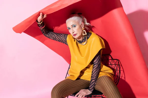 Attentive elderly woman posing on camera in studio — Stock Photo, Image