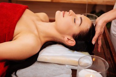 Ahşap masanın üzerinde yatan uzun at kuyruğu ile sakin sakin kadın