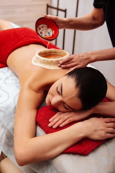 Entspannte langhaarige Frau ruht sich auf Massagebett aus — Stockfoto