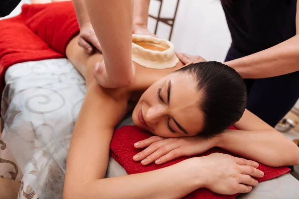 Agradable dama guapa disfrutando de la sensación de aceite caliente en su espalda — Foto de Stock