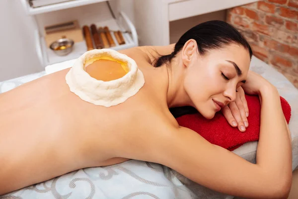 Sakin Bayan Spa kabine kırmızı havlu yatan gülümseyen — Stok fotoğraf