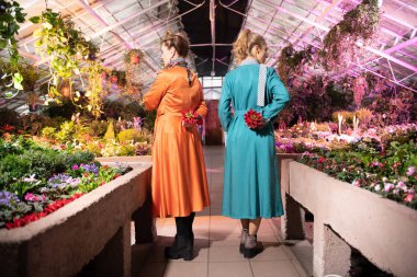 Sırtlarına arkasında çiçek tutan güzel çekici kadınlar