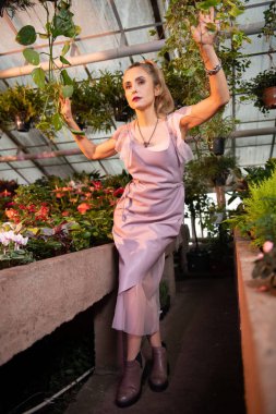 Güzel bitkiler arasında çalışan güzel hoş kadın