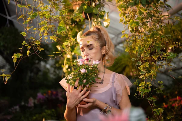Bella giovane donna che sente l'odore delle rose — Foto Stock