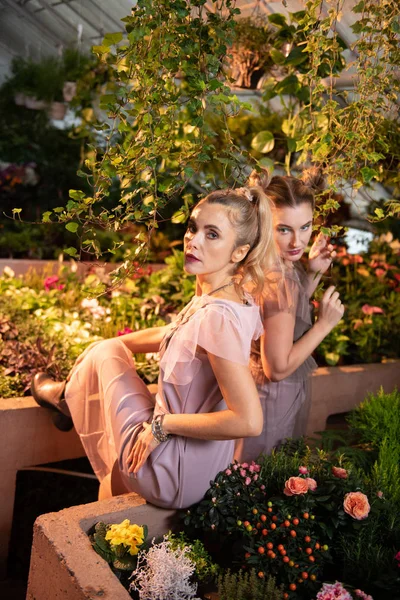 Mooie stijlvolle vrouwen wordt omringd door bloemen — Stockfoto