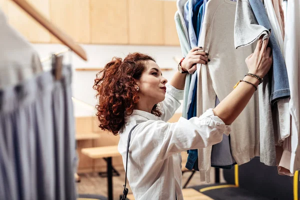 Young curly dark-haired wife choosing present for her husband