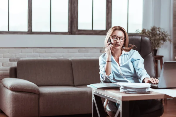 Blond kvinna bär glasögon ringer hennes affärspartner från arbete — Stockfoto