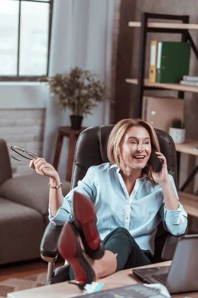 Стильная женщина разговаривает по телефону с другом, чувствуя себя эмоциональным — стоковое фото