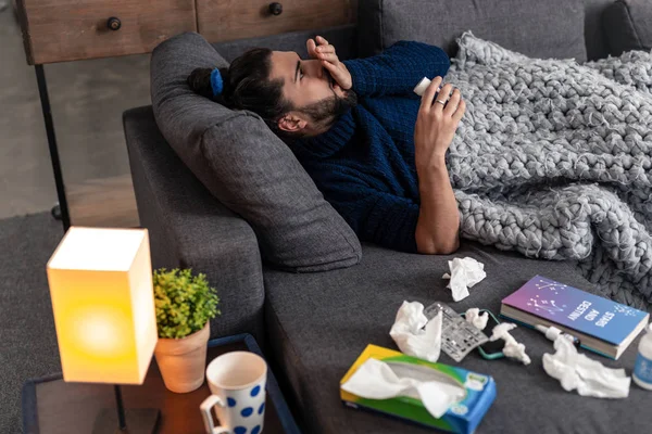 Bonito joven sosteniendo un frasco con pastillas — Foto de Stock