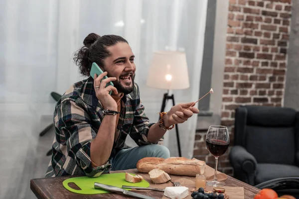 Vrolijke positieve aardige man eten heerlijke kaas — Stockfoto