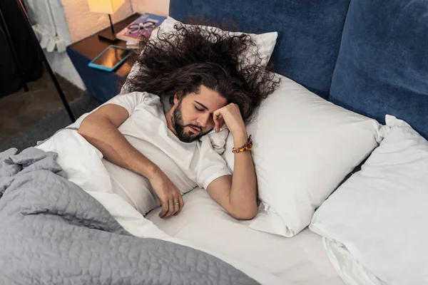 Bonito hombre de pelo largo tratando de dormir — Foto de Stock