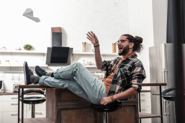 Taburede oturan neşeli memnun adam