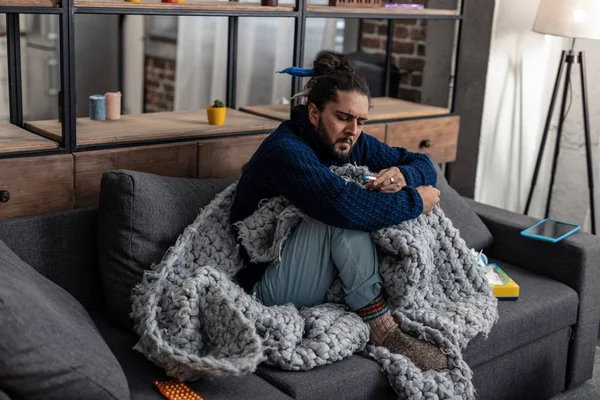 Triste uomo bruna allegro controllando la sua temperatura corporea — Foto Stock