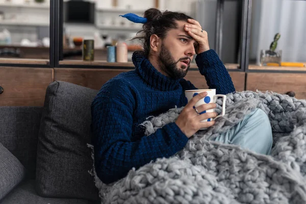 Infeliz joven agradable tocándose la frente — Foto de Stock