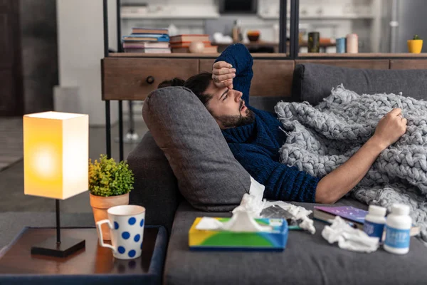 Enfermo infeliz y alegre sosteniendo su frente — Foto de Stock