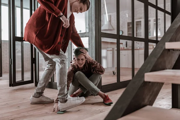 Boyfriend wearing sneakers stepping on phone of his girlfriend