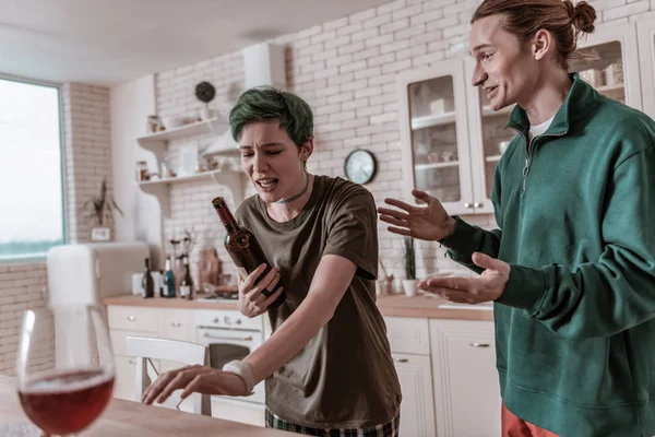 Mulher de cabelos verdes histérica chorando e segurando garrafa de vinho — Fotografia de Stock