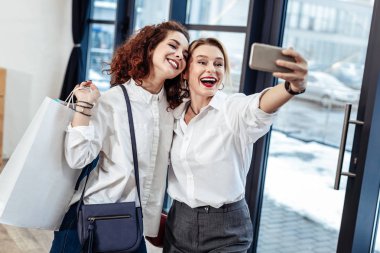 Anne ile fotoğraf yaparken gülümsüyor kıvırcık güzel kızı