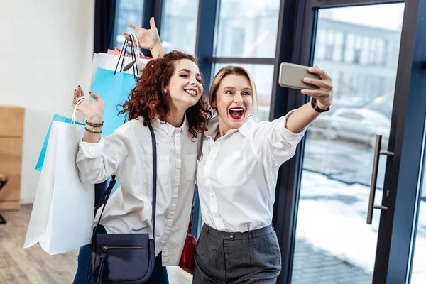 Feliz madre e hija haciendo selfie después de compras exitosas — Foto de Stock