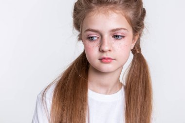 Düz beyaz t-shirt giyen iki uzun kuyrukları sakin ışık saçlı kız