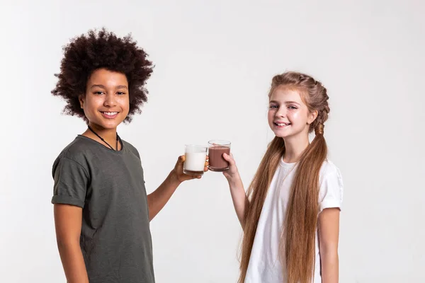 Gioioso bello giovani amici in possesso di latte e cacao — Foto Stock