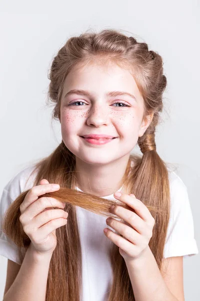 Радісна маленька дівчинка, що носить кінці свого довгого волосся — стокове фото