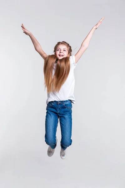 Playful happy blonde girl highly jumping with pulled hands — Stock Photo, Image