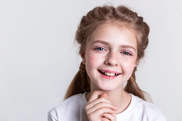 Pequeña niña bonita contenta mostrando sus dientes con una amplia sonrisa — Foto de Stock