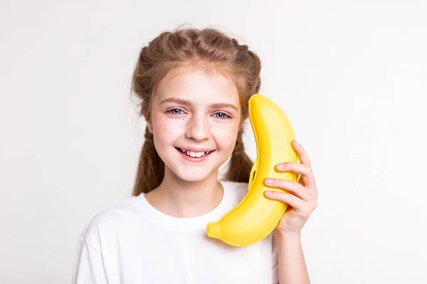Sorridente bella signorina mantenendo grande banana arancione falso — Foto Stock