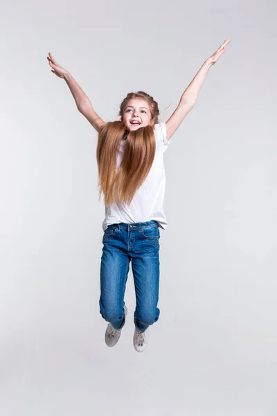 Playful happy blonde girl highly jumping with pulled hands Stock Picture