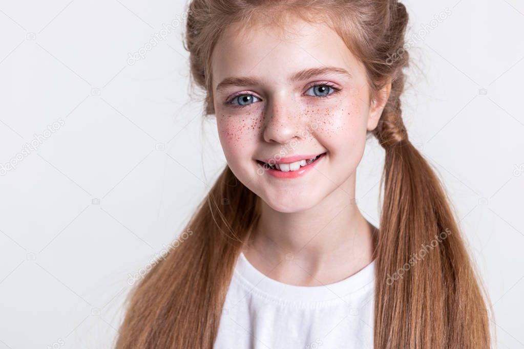 Cute little kid with long light hair and bunch of freckles