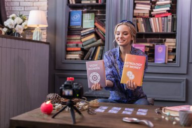 İki kitap tutan olumlu neşeli genç kadın