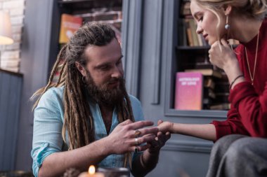 Bir chiromancer çalışan olumlu sakallı adam