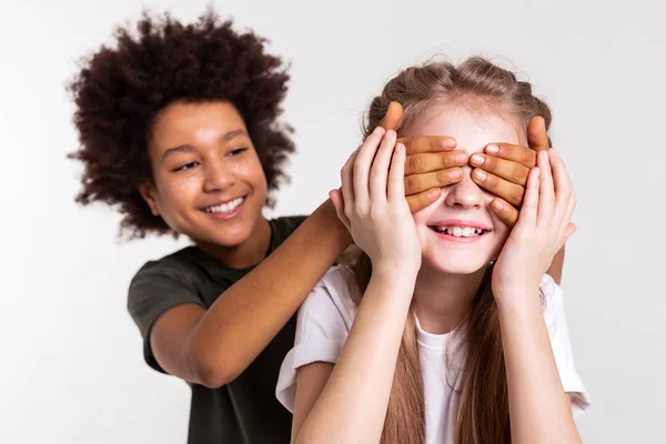 Kindischer dunkelhaariger Junge, der trickreich ist und mit seinem Freund spielt — Stockfoto